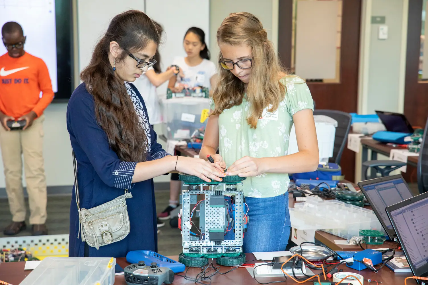 Two female students construct a robot during a STEM workshop 