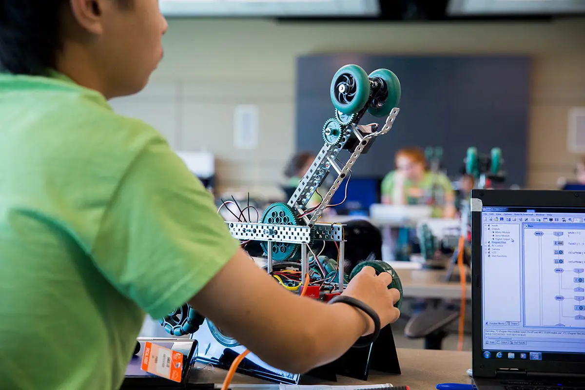 A male student builds and programs a remote-controlled robot