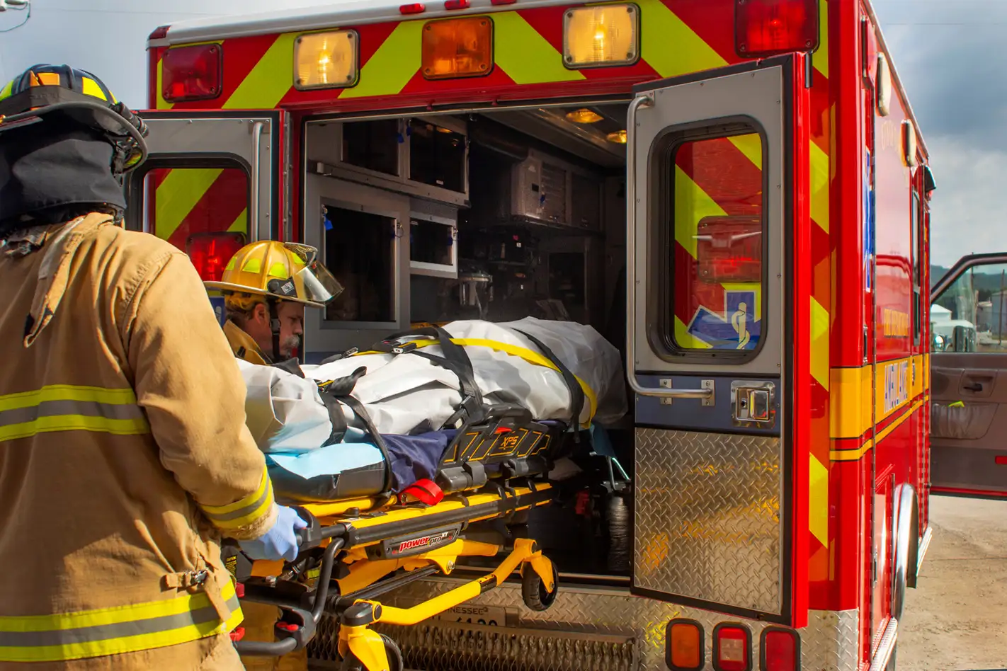Firemen load a patient into an ambulance