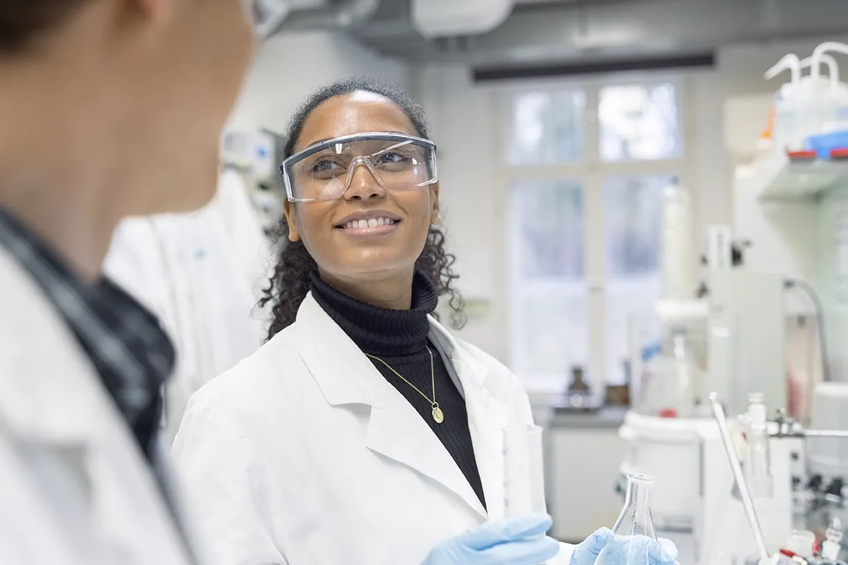 Female scientist discussing with male colleague while working in a lab