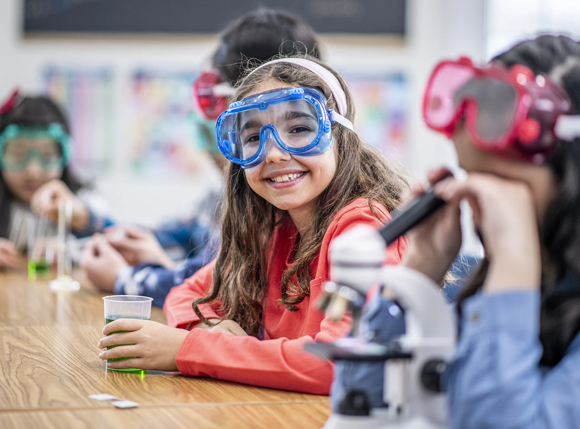 Female student builds a robot vehicle in school computer coding class